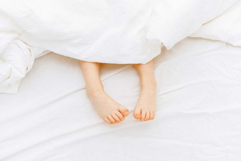person-lying-on-white-bed-3905766