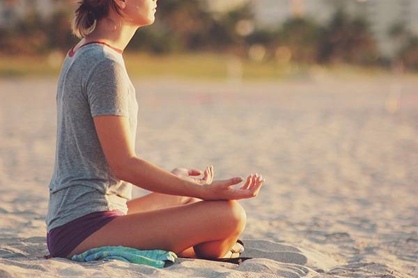 Woman meditating on beach