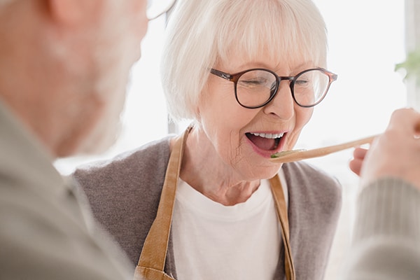 Couple tasting food in kitchen