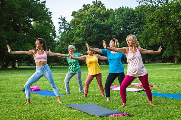 women doing yoga in park