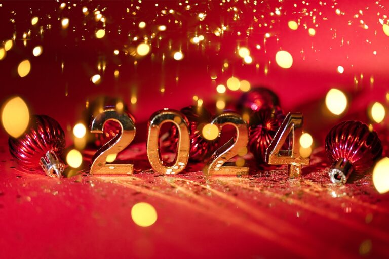 2024 gold colored numbers and glittering confetti on a vivid bright red background.